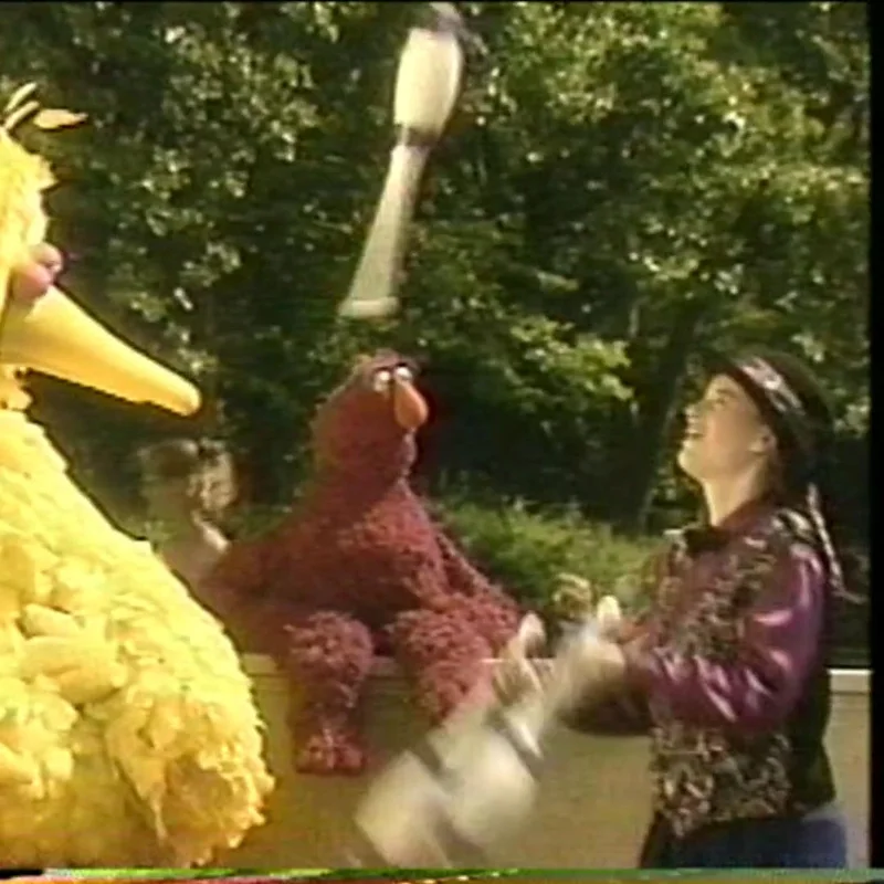 Cindy Marvell juggling clubs beside Big Bird and Telly on Sesame Street